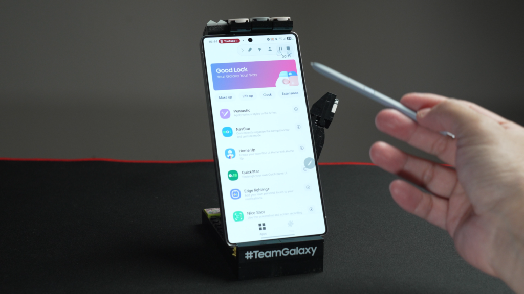 這篇文章將深入探討三星手機用戶絕對不能錯過的「神級外掛」軟體:Good Lock。透過這款由三星官方開發的工具箱,用戶能從系統底層進行深度客製化,包括打造如同「按鍵精靈」般的自動化觸控巨集、找回經典的三鍵手勢導覽、極致簡約的狀態列優化,以及大幅提升單手操作效率的進階手勢。此外,本文也將分享如何透過 Camera Assistant 解鎖相機隱藏焦段,以及運用 Sound Assistant 實現個別應用的音量精細控管,帶領讀者一步步解放三星手機的真實潛能,將裝置轉化為最強大的生產力利器。
# **探索三星手機的神級軟體外掛:Good Lock 的核心價值**
Good Lock 是三星推出的一個外掛程式系統,其本質上並非單一的應用程式,而是一個集結了各式各樣功能增強小軟體的工具箱。這款軟體存在的目的是為了讓用戶能夠超越原廠 One UI 的限制,讓手機的功能更加豐富且具備高度的個人化空間。在 Good Lock 的生態系中,每一款小軟體都有其專精的領域,有些專注於介面美化,有些則致力於操作邏輯的重塑。
最令我感到驚艷的是,Good Lock 內建的功能甚至能讓手機具備類似於「按鍵精靈」的自動化操作能力,也就是所謂的觸控巨集。這意味著用戶可以錄製一連串的螢幕操作動作,並讓手機在特定條件下自動執行,且這種執行層級是無視任何第三方應用程式的,甚至連遊戲程式往往也無法察覺其背後的邏輯變化。除了自動化工具,Good Lock 還涵蓋了聲音輔助、相機功能擴充、狀態列客製化等領域。對於追求極致手機體驗的三星用戶來說,Good Lock 不是可有可無的選項,而是發揮硬體實力的必備軟體。
# **如何正確安裝 Good Lock:三星應用商店的專屬體驗**
Good Lock 並非內建於三星手機的出廠軟體清單中,也不會在 Google Play 商店中出現。要獲取這款強大的工具,必須前往三星自家的應用商店(Galaxy Store)。這可以被視為三星版的應用程式中心,專門提供針對三星硬體優化過的軟體。
進入 Galaxy Store 後,只需在搜尋欄位輸入「Good Lock」,通常第一個出現的結果就是目標軟體。安裝完成後開啟 Good Lock,會發現其介面條理分明地列出了各個功能模組。初次使用時,大部分的模組都顯示為未下載狀態,用戶可以根據自己的需求,點擊右側的下載符號進行個別安裝。過去這款軟體在特定地區(如台灣)的下載與使用並非如此便利,但隨著三星官方的全面開放,現在安裝過程已變得非常直覺且快速。
# **Routines+:讓手機進化為按鍵精靈的觸控巨集**
在 Good Lock 的所有模組中,Routines+ 是我認為最神奇的功能之一。它是三星系統內建「日常與模式」功能的進階進化版。一般的日常模式只能設定簡單的條件觸發,例如睡覺時開啟靜音或工作時切換模式,但 Routines+ 引入了「觸控巨集」的概念。
觸控巨集的功能在於它能夠完整錄製用戶在螢幕上的所有操作路徑、點擊位置與停留時間,並將其儲存為一個可重複執行的指令集。以我自己的使用經驗為例,在照顧小孩的過程中,我需要頻繁使用一個操作邏輯非常不直覺的 App 來記錄餵奶量或如廁時間。為了簡化這個煩瑣的過程,我直接在 Routines+ 中撰寫了一段巨集,現在只需按一個鍵,手機就會自動進入該 App、點擊特定選單並完成記錄。同樣的道理也可以應用在遊戲中,將一些重複性高、機械式的點擊動作轉化為自動執行,極大地減輕了手動操作的負擔。
# **手把手教你製作與設定自動化觸控巨集**
要建立一個專屬的觸控巨集,首先需要進入 Routines+ 的設定介面,選擇「觸控巨集」選項。系統會引導用戶新增一個巨集,並詢問該巨集要在哪一個 App 內執行。選擇好目標 App(例如檔案管理員或特定工具軟體)後,手機會跳轉至該 App 介面,此時畫面中會出現錄製工具列。
點擊「錄製」後,我所做的每一個點擊與滑動都會被系統標記,畫面上會出現動作編號的記號。完成一系列動作後點擊停止並儲存,接著可以為這個巨集命名。在儲存設定中,還有幾個關鍵的參數可以調整,例如「開始延遲時間」,我通常會設定約五到十秒,給予 App 開啟與載入畫面的緩衝時間;另一個則是「重複次數」,最高可設定至 999 次,讓巨集持續不斷地運作。最後,我還能設定觸發條件,比如透過手勢按一下觸發,或者結合特定的時間、地點、甚至行程結束來自動跑這段巨集,讓手機在特定時段代替我完成打卡或複雜的設定。
# **提升生產力的 AI 輔助利器:Manas AI 的應用**
在談論手機功能的客製化之餘,現代的生產力工作也離不開 AI 的輔助。Manas AI 是一款超越單純文字對話的強大生產力工具。它能快速將 PDF 檔案轉化為高品質的簡報(PPT),甚至能在簡報中自動插入圖表並自訂樣式。這類工具對於需要快速整理資訊的專業人士來說非常實用。
Manas AI 的強大之處在於它集成了簡報、網站、試算表、圖形、影片及音訊的多重生成能力。它甚至能運用最新的 VEO 3 引擎來製作影片,這對於需要製作 YouTube 片頭或 B-roll 素材的內容創作者而言是一大福音。此外,它具備操作瀏覽器與撰寫 Python 程式碼進行數據爬蟲的功能,最誇張的是,它能同時召喚上百位 AI 助手進行協作與溝通。這種團隊化的 AI 協作模式,讓個人也能具備如同百人團隊般的執行效率,將工作流從單打獨鬥升級為指揮調度。
# **NavStar:找回經典手勢並打造隱形導覽列**
隨著 Android 版本的演進,三星的導覽列預設逐漸轉向單一條狀的滑動手勢。然而,對於習慣早期三鍵手勢(多工、首頁、返回)操作的用戶來說,現行的設定往往顯得限制重重,甚至在原生設定中找不到調整回舊式三鍵手勢的選項。這時 NavStar 就能派上用場。
開啟 NavStar 中的「Enable Extra Gesture Settings」後,系統會釋放出更多進階的滑動手勢選項。這讓用戶可以找回從底部向上滑動來分別對應返回、首頁與多工的三條式手勢,兼顧了手勢導覽的簡潔與物理位置的直覺感。除了操作邏輯的變更,NavStar 還支援導覽列的視覺自訂。我可以將導覽列設定為完全透明,讓螢幕視覺效果更加完整,或者根據個人喜好為導覽列添加色彩與不同的圖標,讓手邊的手機介面與眾不同。
# **QuickStar:重塑乾淨整潔的系統狀態列**
手機頂端的狀態列(Status Bar)在安裝了許多 App 後常會顯得極度混亂,各種通知、系統圖示(如 NFC、省電模式、音量狀態)擠在一起,視覺壓力非常大。QuickStar 的核心功能就是對這些圖樣進行「斷捨離」。
透過 QuickStar,我可以精細地設定哪些系統圖示要顯示,哪些要永久隱藏。例如,我不喜歡在狀態列看到靜音圖示,或者想關掉 NFC 顯示,只需在選單中關閉即可。更進階的功能還包括對時鐘的調整,我可以選擇隱藏時鐘、將時鐘移至左側或右側,甚至能讓時鐘顯示出秒數或日期。這種高度的客製化權限,讓用戶能打造出一個極致乾淨、只保留重要資訊的系統介面,大幅提升了操作手機時的視覺舒適度。
# **GoingBus:數位服務訂閱的省錢策略**
在追求極致硬體體驗的同時,如何優化軟體服務的訂閱開銷也是一門學問。GoingBus 是一個線上帳號共享平台,其宗旨在於讓用戶以更實惠的價格使用主流的訂閱服務,如 Netflix、Disney+、YouTube Premium、Spotify 等,甚至連 ChatGPT、Canva、Duolingo 這種工具類服務也包含在內。
以影音平台為例,透過 GoingBus 的共享合租模式,每個月的費用幾乎能降低一半。雖然是合租,但用戶可以針對自己的子帳號進行隱私上鎖,確保觀看記錄不被他人窺視。對於工具類如 ChatGPT 的訂閱,雖然可以看到其他人的查詢記錄(可透過無痕模式緩解),但考慮到長期訂閱所省下的四到五成費用,這依然是一個非常有競爭力的節費方案。這類平台通常支援購買後 24 小時內的退款機制,對於精打細算的用戶來說,是降低數位生活成本的有效管道。
# **One Hand Operation+:三星最強大的進階手勢系統**
如果讓我票選三星手機買來後第一個要安裝的軟體,那絕對非 One Hand Operation+ 莫屬。這款軟體極大地強化了單手操作的靈活性。在安裝後,螢幕左右側邊會出現可自訂的觸控點,讓用戶在任何畫面下都能透過側邊滑動來執行特定指令。
我個人最常用的設定是:向內滑動代表「返回」,向上滑動開啟「多工介面」,向下滑動則是回到「首頁」。除此之外,它還支援「滑動並按住」的進階動作。例如,我設定在右側向上滑動並按住,就會彈出一個自定義的「快速工具欄」。這個工具欄可以讓我快速截圖、開啟計算機或進入常用的應用程式,完全不需要回到桌面尋找圖標。One Hand Operation+ 甚至允許針對 S Pen 進行手勢優化,並能排除特定不希望被手勢干擾的 App,其強大的功能性與高度的自由度,讓大螢幕手機的單手掌控感得到了質的飛躍。
# **Nice Shot:讓螢幕截圖與編輯變得更加直覺**
三星原生的截圖功能雖然堪用,但在某些細節上仍有提升空間。Nice Shot 這個模組專門針對截圖體驗進行優化。最實用的一個改變就是在截圖後的工具列中直接加入「垃圾桶按鈕(Delete Button)」。
在沒有這個功能的情況下,如果你不小心截錯了圖,必須事後進入相簿刪除;但開啟 Nice Shot 後,截圖當下若發現畫面不對,直接點擊垃圾桶圖示,該圖像就會立即被刪除,不會佔用任何儲存空間。另外,Nice Shot 還提供了一個「取消裁剪捕捉(Disable crop snapping)」的功能。有時候系統會自動判斷並幫用戶把截圖畫面縮放到它認為合適的大小,但這往往不是用戶想要的,透過這個選項可以關閉自動縮放,讓用戶保留最原始、最完整的截圖區域。
# **Camera Assistant:解鎖相機焦段捷徑與柔化效果**
對於熱愛攝影的三星用戶來說,Camera Assistant 是提升相機操作效率的關鍵。原生的相機介面在焦段切換上可能只有 0.6x、1x、3x、5x 等預設值,但透過這款外掛,我可以開啟「變焦捷徑」,加入極其好用的 2 倍與 10 倍焦段。
2 倍變焦在日常拍攝食物或人像時是非常理想的物理焦段,有了捷徑後,我就不需要再用手指在螢幕上辛苦地縮放尋找,只需點一下按鈕就能精準切換。此外,Camera Assistant 還提供了「相片柔化」功能,這對於不喜歡三星預設那種過於銳利、數位感過重畫質的人來說非常有用,可以選擇中度或高標的柔化,讓成像風格更加溫潤、自然。功能中還包含「鏡頭自動切換」的開關,用戶可以決定要讓系統根據環境光源自動選用鏡頭,還是強行固定使用特定鏡頭以確保畫質,這些隱藏設定大大增加了拍攝時的掌控力。
# **Sound Assistant:打造精細的音量管理系統**
最後要介紹的是 Sound Assistant,這款軟體將手機的聲音控制提升到了專業等級。它最核心的功能之一是「個別應用程式音量」。在日常使用中,有些 App 的音量預設非常大(如某些遊戲或銀行 App 的提示音),而有些則偏小。透過 Sound Assistant,我可以針對單一 App 設定最大音量的百分比,確保切換應用時不會被突如其來的爆音嚇到。
另一個對我非常有幫助的功能是「變更音量範圍」。預設情況下,按一次音量鍵調整的格數可能太大,導致聲音不是太小就是太大。我會將其從預設的 10 改為 5 甚至更細,這樣就能進行更精微的音量微調。最後,Sound Assistant 還提供了五彩繽紛且樣式豐富的「音量面板」客製化選項。我可以將單調的垂直音量條換成浮誇的設計,並在面板中加入等化器、字幕偵測、媒體輸出切換等快捷按鈕。這讓原本單純的音量調整動作,變成了一個強大的多媒體調控中心。
# **Good Lock 是三星手機靈魂的完整體現**
回顧上述所有的功能模組,從 Routines+ 的自動化觸控、One Hand Operation+ 的極致單手操控,到相機與聲音的深層優化,Good Lock 展現了三星對於硬體與軟體結合的深厚底蘊。這套工具的存在證明了三星手機具備極高的上限,只要用戶願意花時間探索,就能將手邊的裝置打造成最符合自己直覺的完美形態。如果作為一名三星用戶卻從未使用過 Good Lock,那無疑是白費了這支手機強大的擴展潛力。手機不應只是出廠時的樣子,透過這些超神軟體的加持,每個人都能擁有一支獨一無二的三星手機。
手機的功能進化就像是一場沒有終點的馬拉松,而 Good Lock 就是那雙能讓你在這場長跑中更加省力且跑得更遠的專業跑鞋。