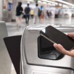 iPhone 靠近捷運閘門感應區準備使用 Apple Pay 進站