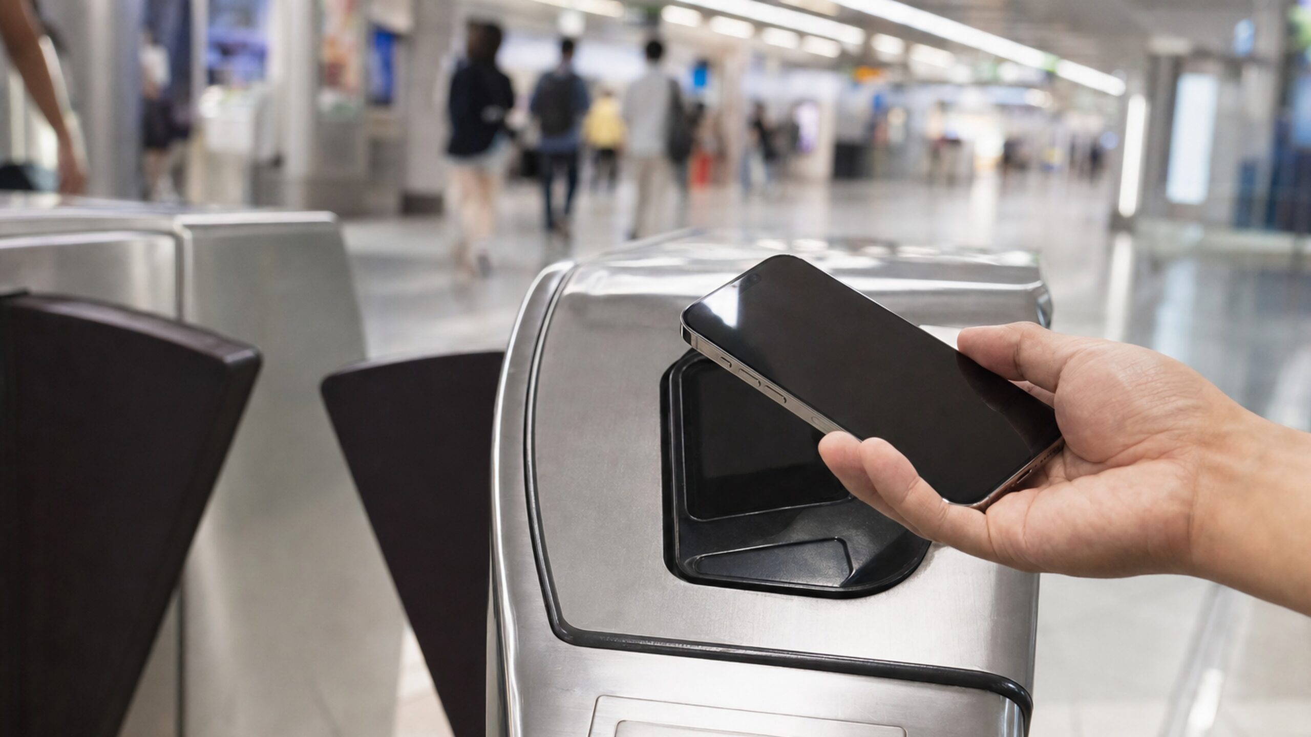 iPhone 靠近捷運閘門感應區準備使用 Apple Pay 進站