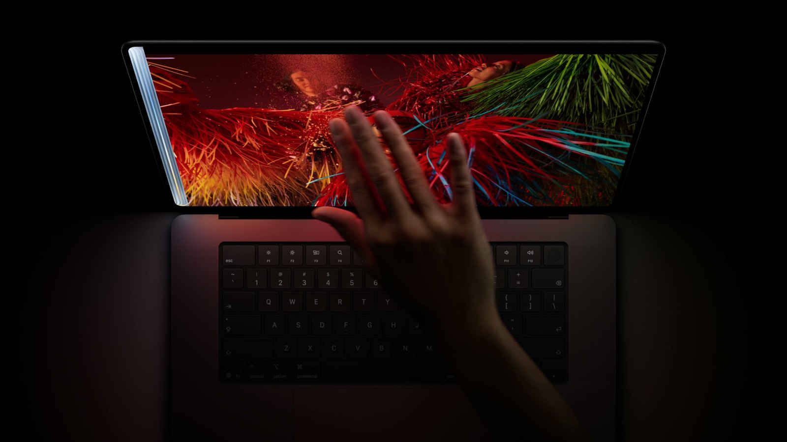 從上方看 MacBook Pro,一隻手直接在螢幕上滑動操作